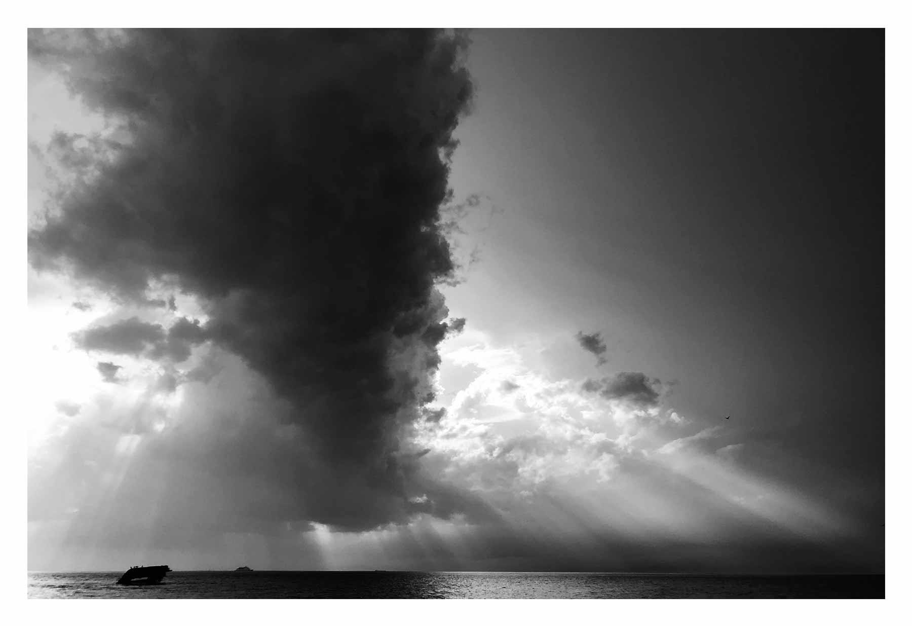 A large cloud builds over the water