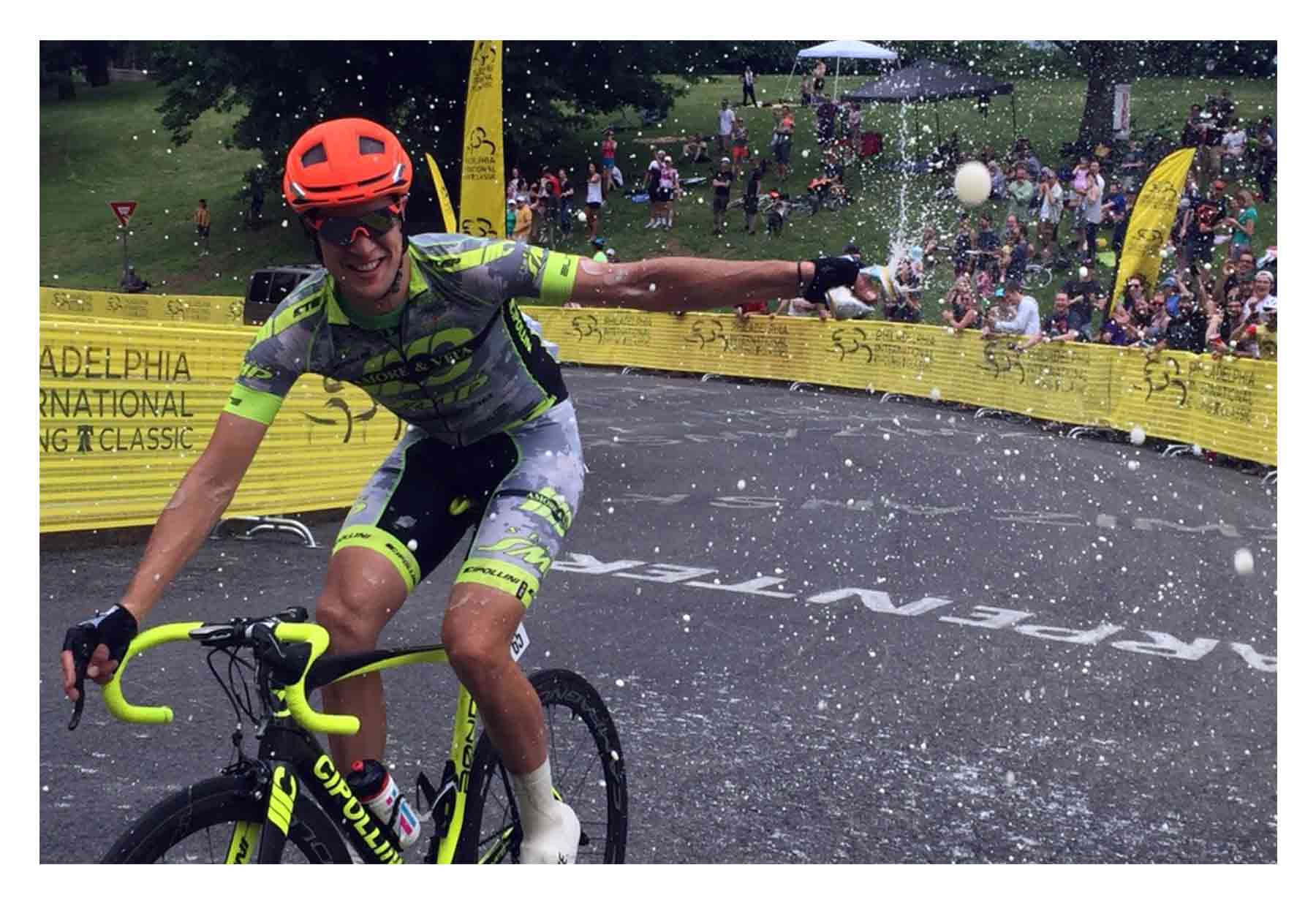 A bike racer throws beer towards the camera
