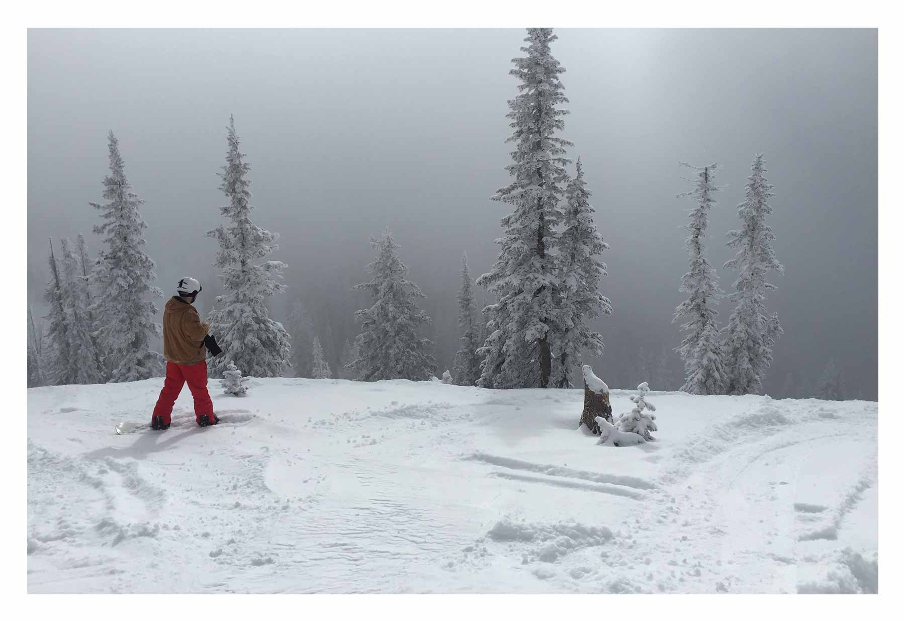 A snowboarder awaits descent